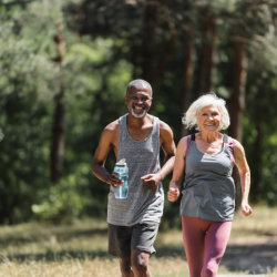 Loving elderly wife and husband jogging outdoor.