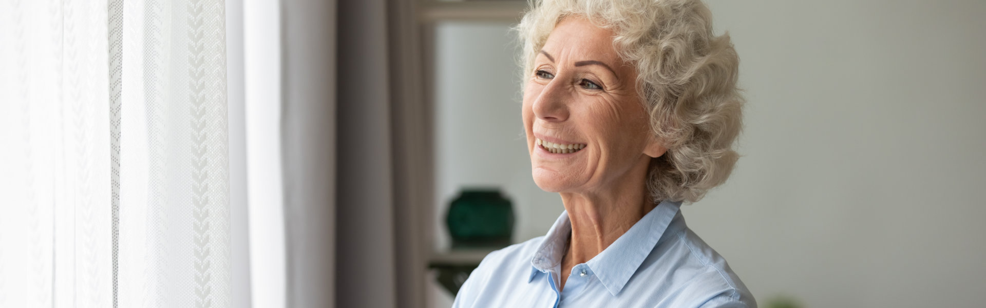 Happy elderly woman look in the window.