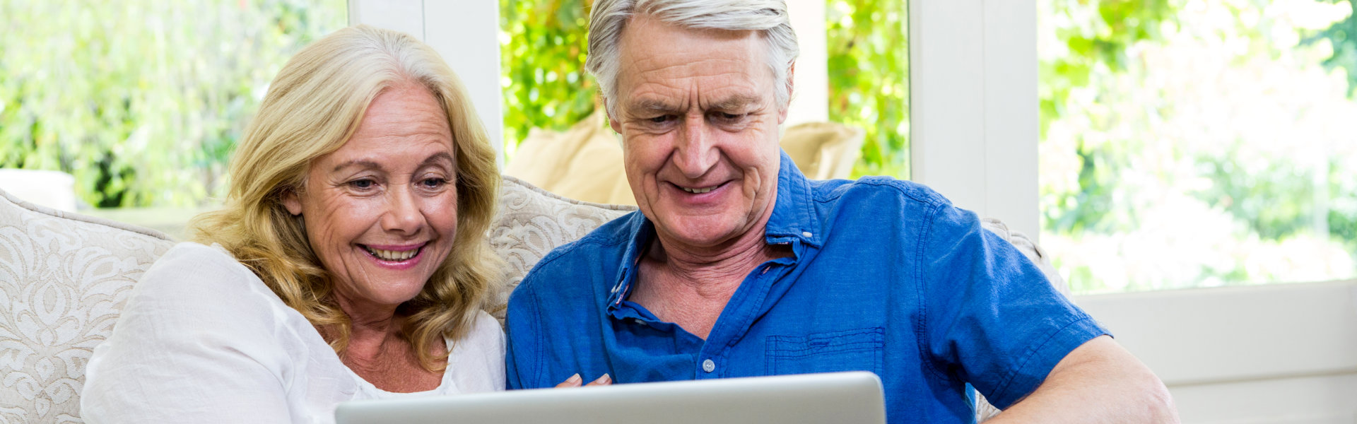 Loving seniors using laptop together.