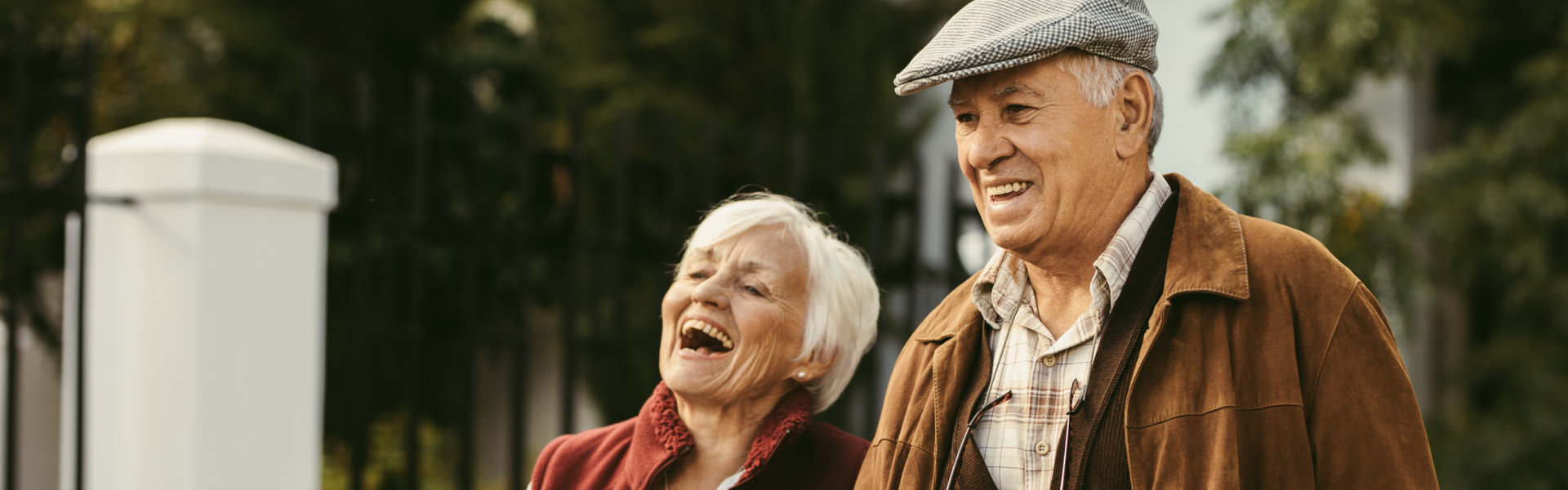 Portrait of old man and woman wearing warm clothing walking together.