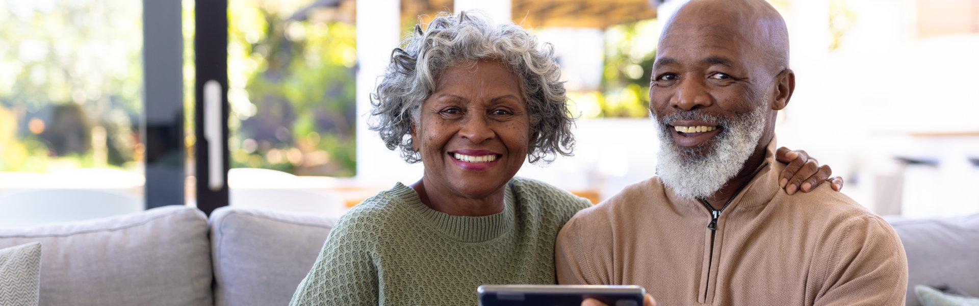 Portrait of smiling african american senior friends with digital pc.